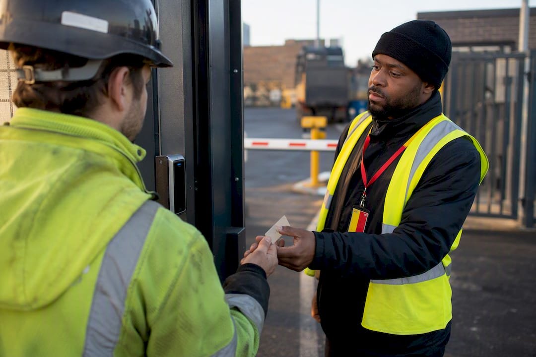 Officer checking subcontractor entry at site gate