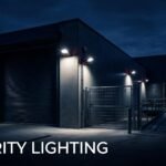 A warehouse site at dusk with bright security lights and a CCTV camera.